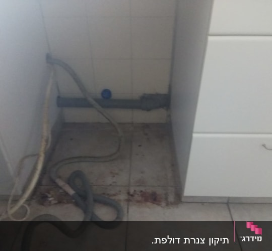 צינור מים מתחת לכיור עם לכלוך על הרצפה